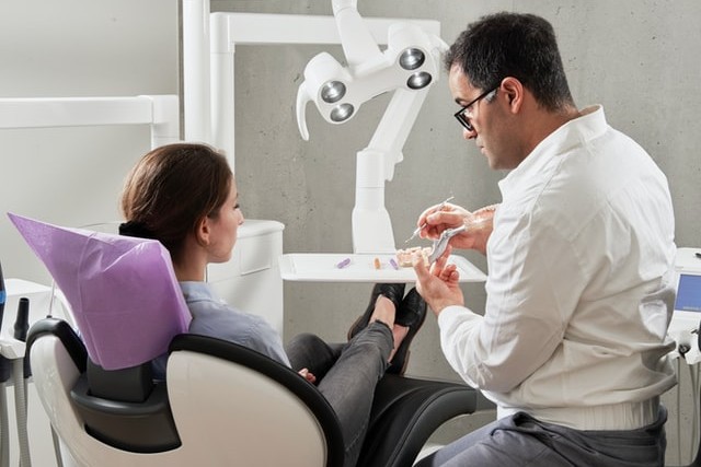 woman sat in dentist chair with dentist during check up