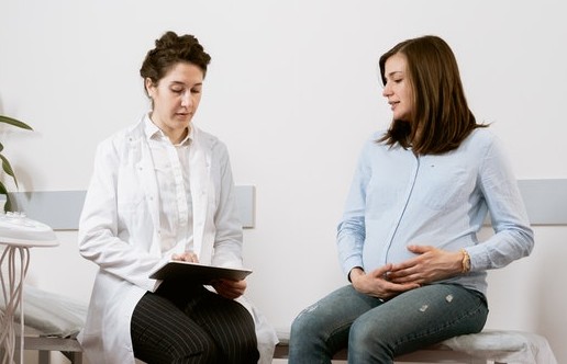 GP speaking to pregnant woman