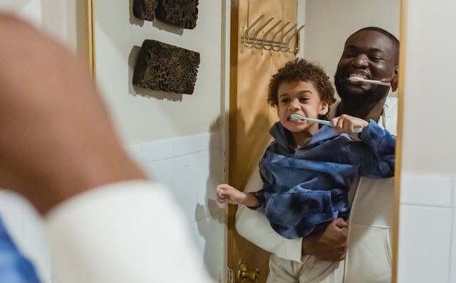 father and son brushing teeth together